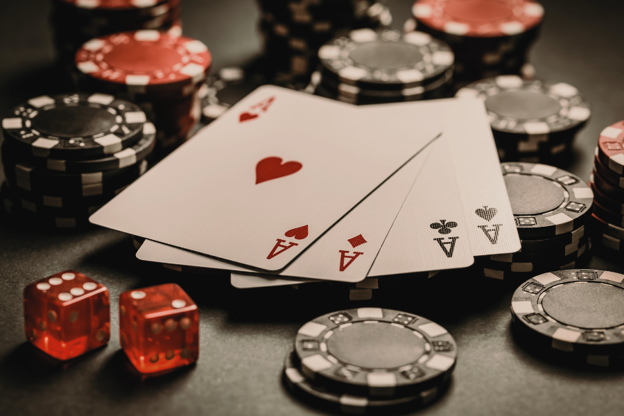 Casino coins and 2 dice with some cards of a deck of cards